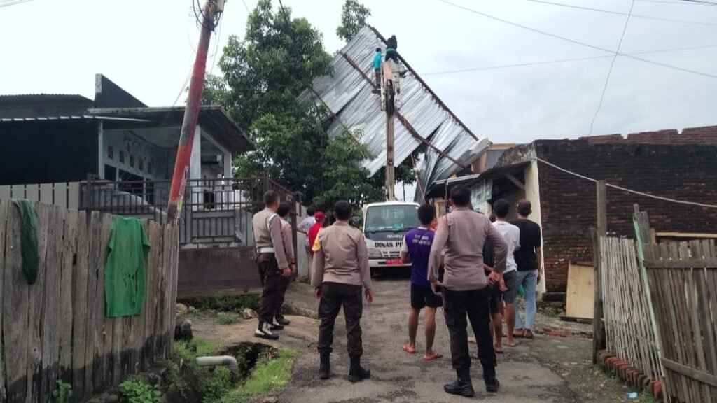 Petugas bersama pemda Sumbawa gotong royong turunkan atap rumah warga nyangkut di pohon usai diterjang angin kencang, Rabu (13/3/2024).