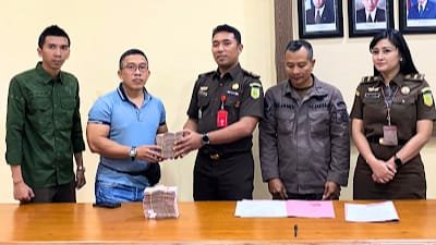 Kepala Seksi Tindak Pidana Khusus I.B.P. Swadharma Diputra, SH.,MH didampingi Kepala Seksi Intelijen I Putu Bayu Pinarta, SH.,MH bersama keluarga terpidana saat menyerahkan uang sebesar Rp 200 juta, Kamis (22/8/2024).