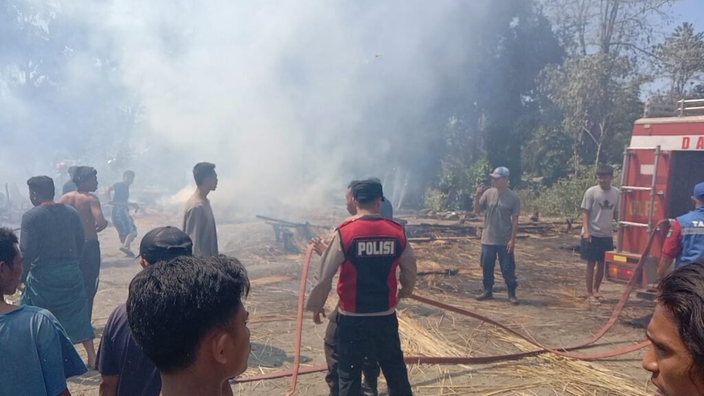 Warga dan petugas saat lakukan proses pendinginan di lokasi kebakaran rumah di Bayan Lombok Utara, Jumat (23/8/2024).