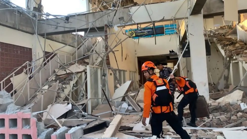 Petugas melakukan penanganan di tengah bangunan yang rusak akibat gempa M7,7 di Nusa Tenggara Timur, Sabtu (15/8/2026).