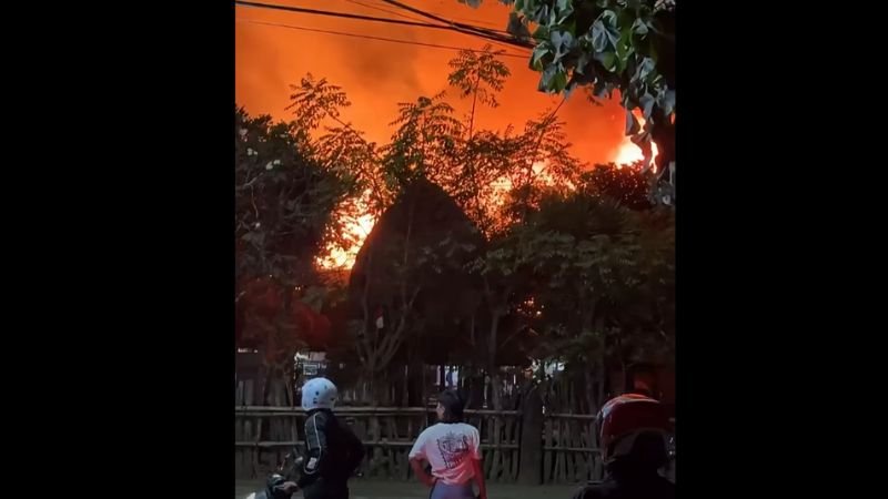 Kobaran api terlihat membesar di kawasan Desa Adat Sade, Desa Rembitan, Kecamatan Pujut, Lombok Tengah, Sabtu malam (22/8/2026). Hingga berita diterbitkan, jumlah bangunan terdampak, korban, dan penyebab kebakaran masih dalam proses konfirmasi. Foto: tangkapan layar video warga.