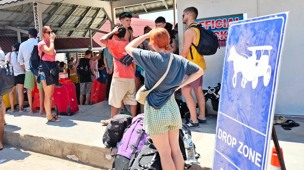 Wisatawan dengan barang bawaan berada di kawasan keberangkatan Gili Trawangan, Kabupaten Lombok Utara. Krisis air bersih dilaporkan menyebabkan sekitar 300 tamu melakukan early check-out dari sejumlah hotel. (Foto: kicknews.today)