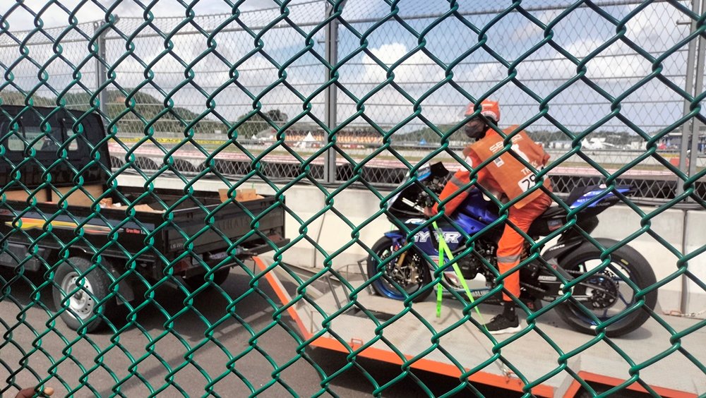 Seorang marshal mengevakuasi sepeda motor pembalap yang mengalami crash di Pertamina Mandalika International Circuit. Peran marshal menjadi salah satu bagian penting dalam operasional MotoGP Mandalika, termasuk dalam penanganan insiden di lintasan. Foto: Doc. KickNews.Today