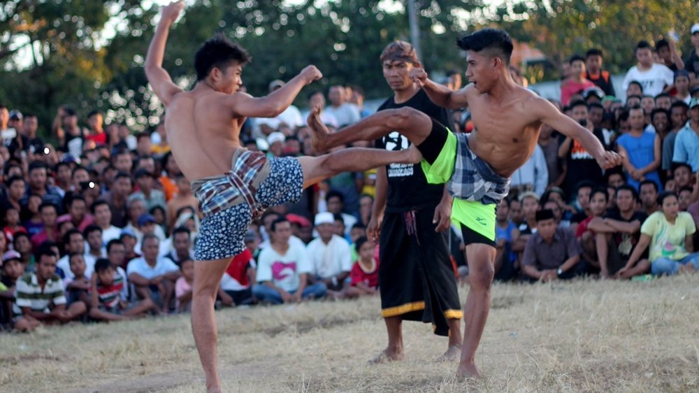 Dua pepadu beradu dalam tradisi Belanjakan, permainan tradisional masyarakat Masbagik, Lombok Timur. Belanjakan Masbagik resmi ditetapkan sebagai Warisan Budaya Takbenda Indonesia tahun 2026. (Foto: Istimewa)