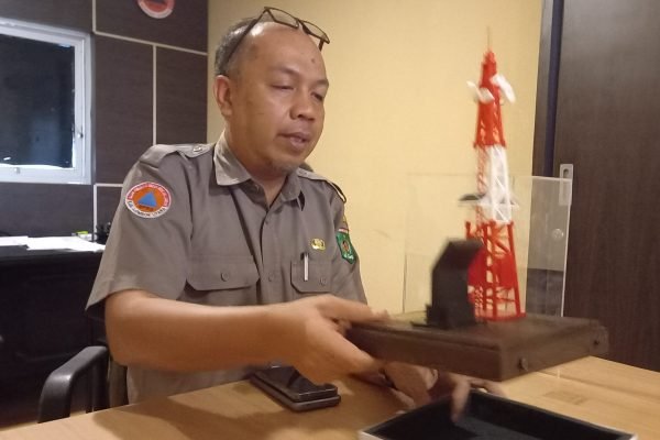 Kepala BPBD KLU, M. Zaldy Rahadian saat menunjukkan miniatur tower peringatan dini tsunami. (Foto. kicknews.today/Anggi)