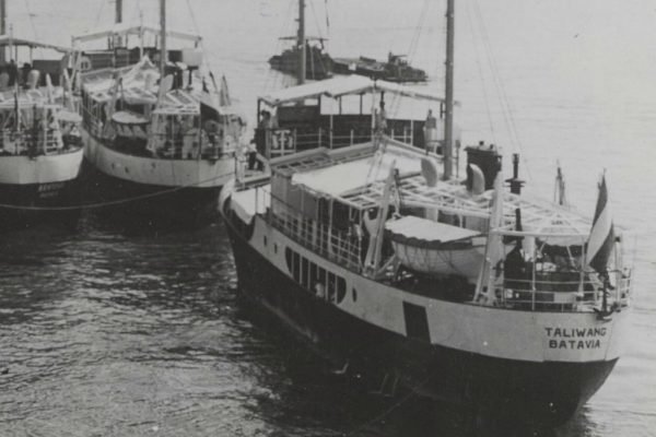 Kapal pesisir Taliwang dengan pelabuhan registrasi Batavia bersandar bersama kapal sejenis pada 1947. Kapal berbadan baja ini berlayar dari Rotterdam menuju Indonesia dan kemudian digunakan untuk mengumpulkan kopra di kawasan timur Indonesia. (Dok. Marhisdata/Kombuispraat)
