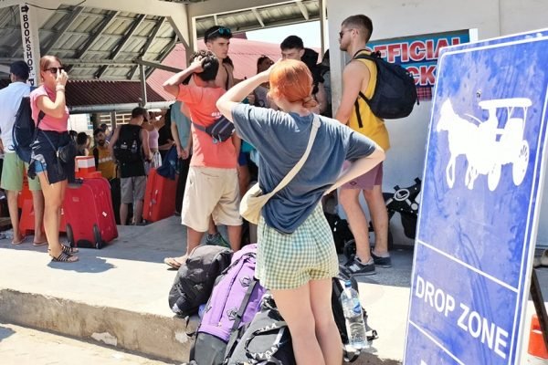 Wisatawan dengan barang bawaan berada di kawasan keberangkatan Gili Trawangan, Kabupaten Lombok Utara. Krisis air bersih dilaporkan menyebabkan sekitar 300 tamu melakukan early check-out dari sejumlah hotel. (Foto: kicknews.today)