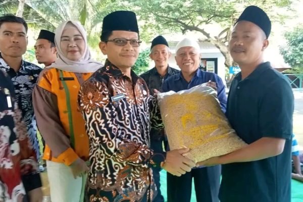 Pj Sekda KLU saat memberikan benih padi kepada salah satu warga di Kecamatan Gangga. (Foto. dok Prokopim Setda KLU)