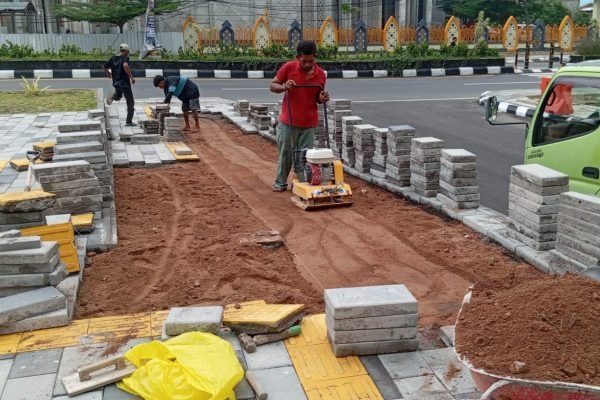 Beberapa pekerja saat memperbaiki beberapa titik paving block yang mengalami kerusakan. (Foto. kicknews.today/Ist)