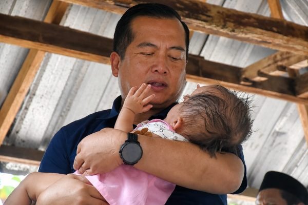 Gubernur NTB Dr H Lalu Muhamad Iqbal saat menggendong bayi pengidap penyakit hidrosefalus. (foto kicknews.today/adpim)