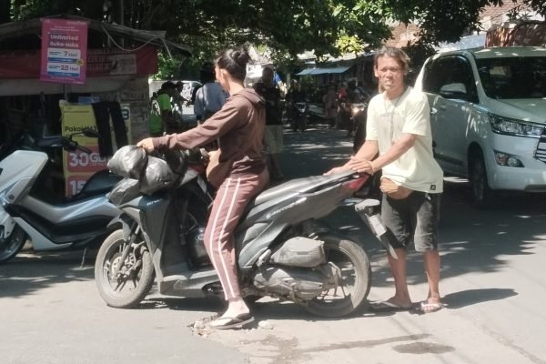 Edy saat melakukan aktivitas di area parkir pakean bekas di pasar karang sukun Mataram (foto kicknews.today/wn)