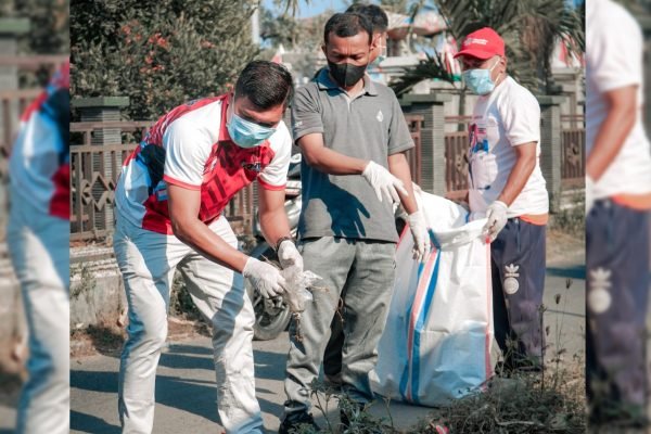 Anggota DPRD KLU dari Fraksi Gerindra, Artadi (baju merah) saat membersihkan sampah di area pasar Tanjung. (Foto. kicknews.today/Ist)