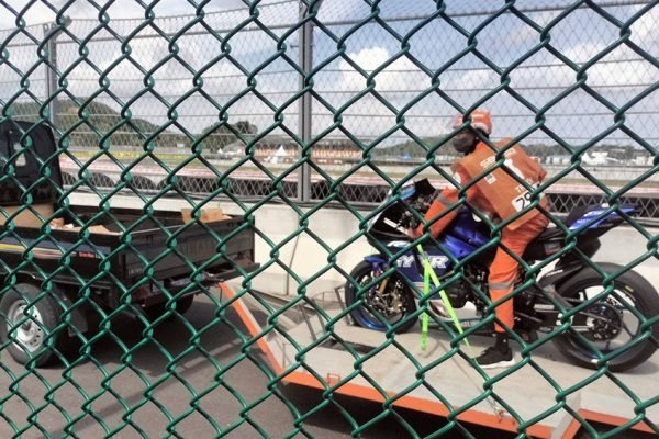 Seorang marshal mengevakuasi sepeda motor pembalap yang mengalami crash di Pertamina Mandalika International Circuit. Peran marshal menjadi salah satu bagian penting dalam operasional MotoGP Mandalika, termasuk dalam penanganan insiden di lintasan. Foto: Doc. KickNews.Today