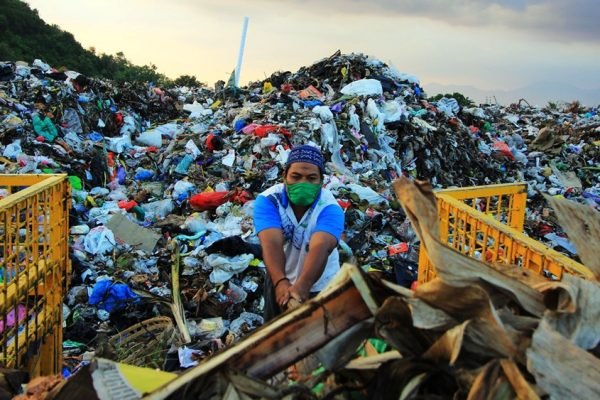 Seorang pekerja memilah sampah di tengah tumpukan yang menggunung di TPA Regional Kebon Kongok, Kabupaten Lombok Barat. Kapasitas yang semakin penuh membuat pembuangan sampah dari Kota Mataram kembali dibatasi. (Foto: Dokumentasi Pemprov NTB)