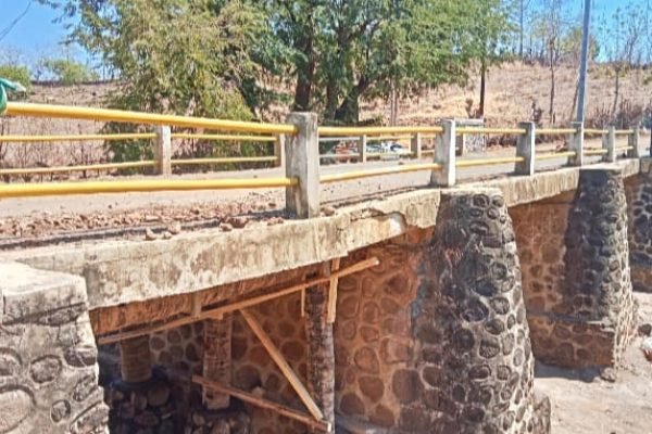 Jembatan lintas provinsi lingkar utara di Desa Punti Kecamatan Soromandi Kabupaten Bima, retak dan disangga balok kayu.