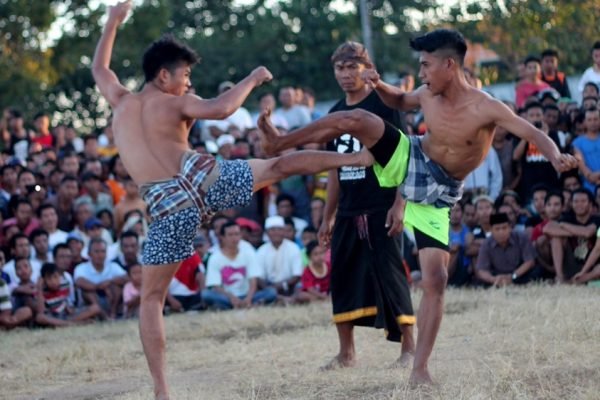 Dua pepadu beradu dalam tradisi Belanjakan, permainan tradisional masyarakat Masbagik, Lombok Timur. Belanjakan Masbagik resmi ditetapkan sebagai Warisan Budaya Takbenda Indonesia tahun 2026. (Foto: Istimewa)