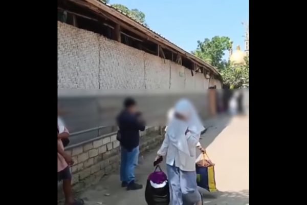 Seorang santriwati membawa barang bawaan saat meninggalkan pondok pesantren di Desa Bunkate, Kecamatan Jonggat, Lombok Tengah, Senin (22/9/2026). Sejumlah wali santri menjemput anak mereka setelah dugaan kekerasan seksual di lingkungan pesantren tersebut viral. (Foto: tangkapan layar)